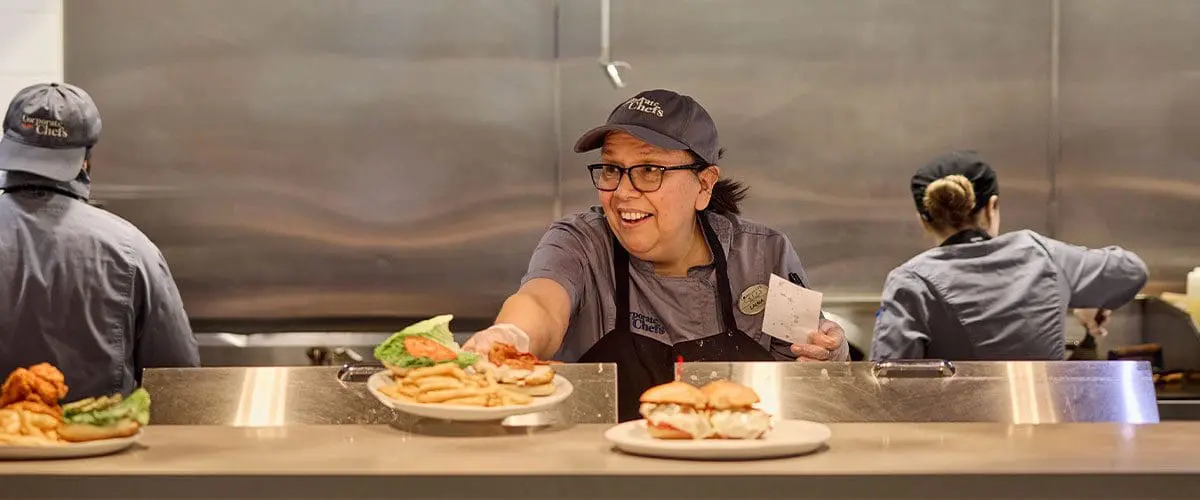 Employee smiling at customer from behind counter