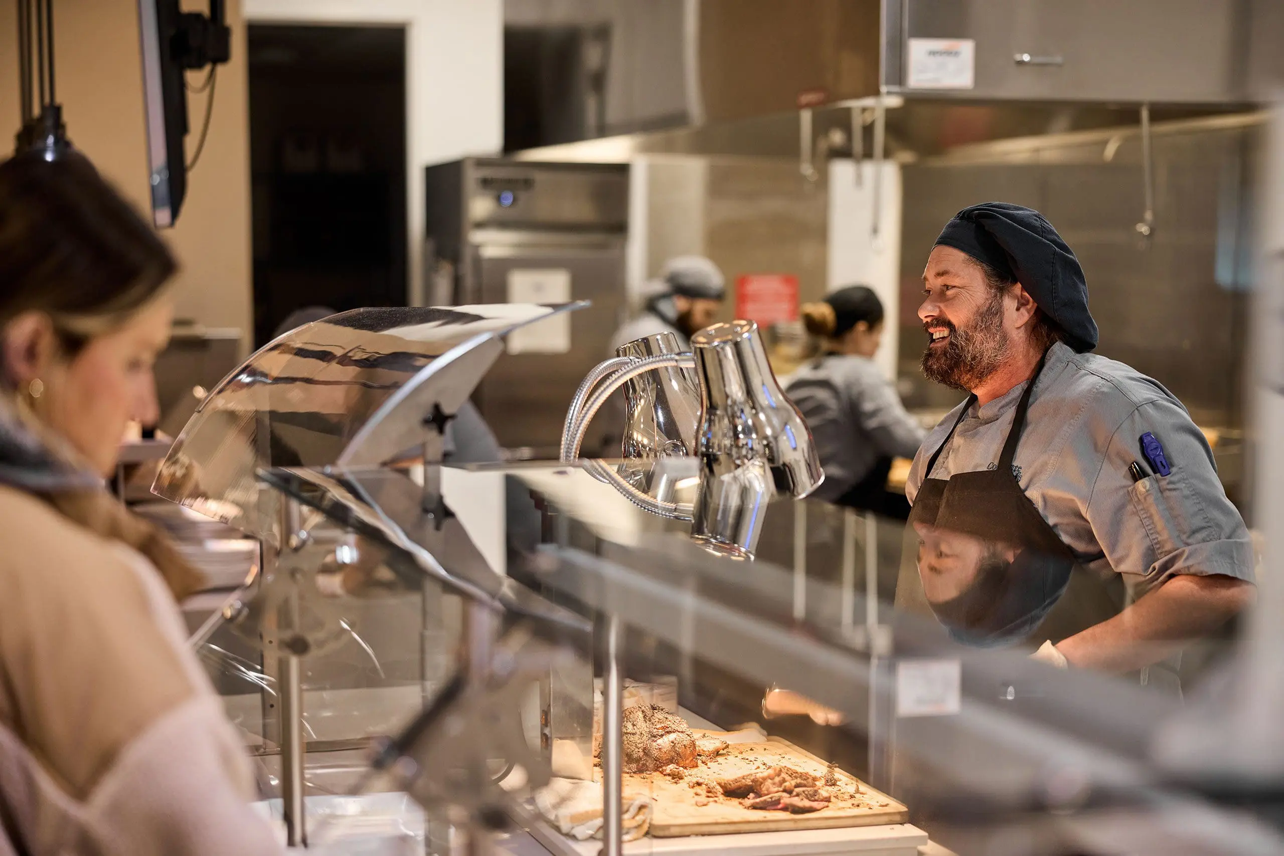 Employee behind counter smiling and serving customer